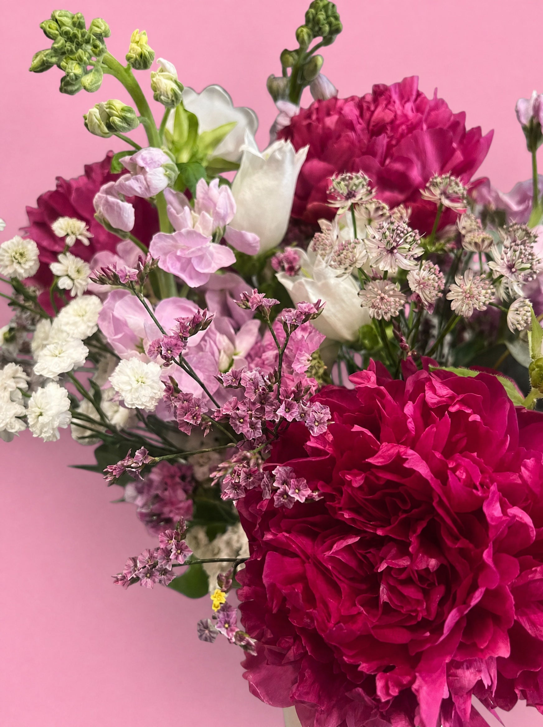 Bouquet de Fête des Mères ÂME Bordeaux en gros plan : pivoines fuchsia, pois de senteur poudrés, astrantia blanche et statice rose composés à la main