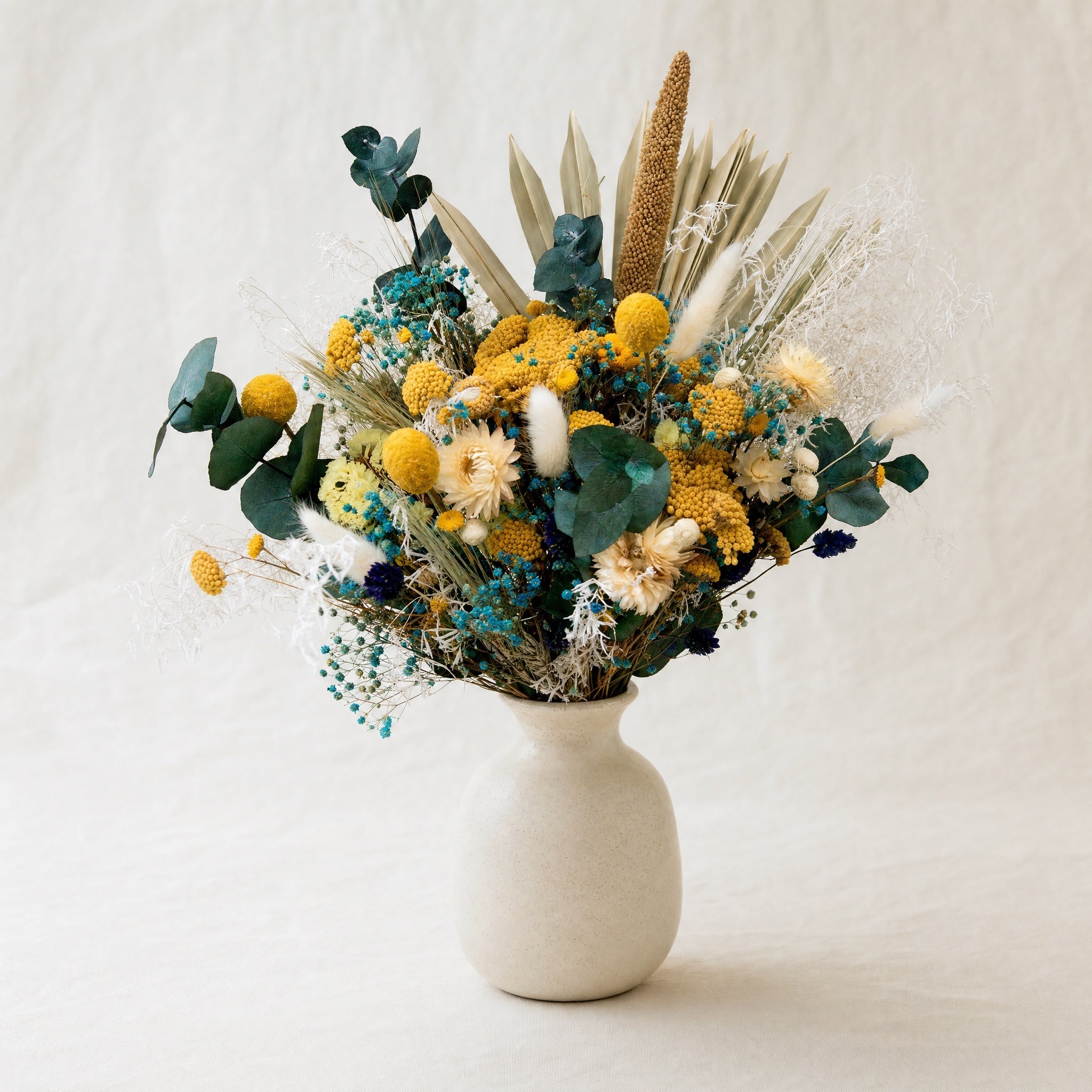 Bouquet fleurs séchées Bordeaux — palette jaune moutarde et bleu en vase céramique — fleurs Bordeaux | ÂME Fleuriste Bordeaux