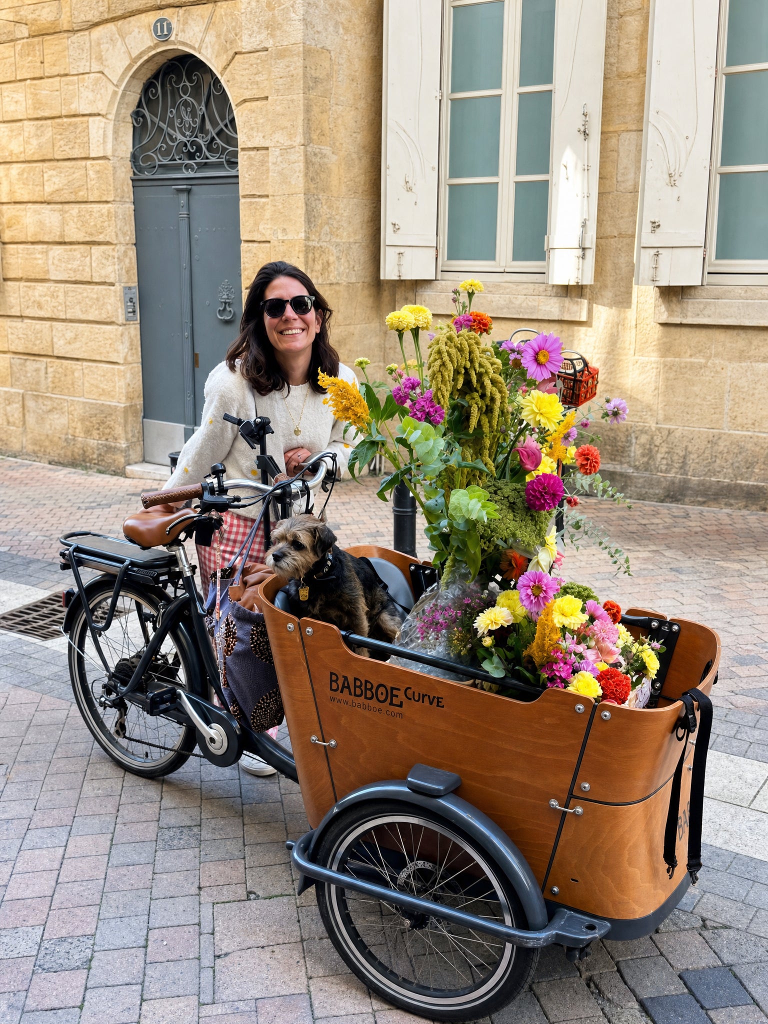 Victoria Laubie, fondatrice d'Âme, livre un bouquet de fleurs fraîches en vélo cargo dans les rues de Bordeaux | ÂME Fleuriste Bordeaux